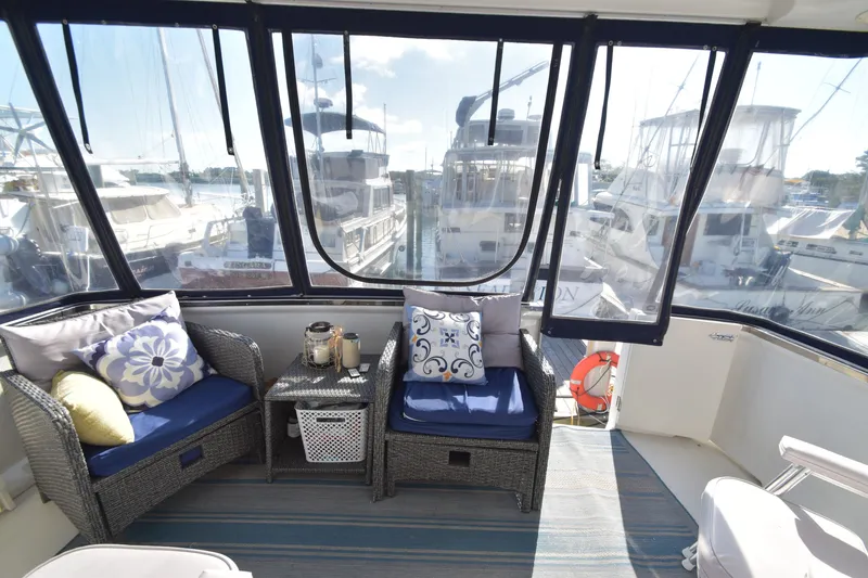 Slide: The Image of The 2000 Carver 356 Aft Cabin Motor Yacht features a cozy seating area with blue cushions. - 16