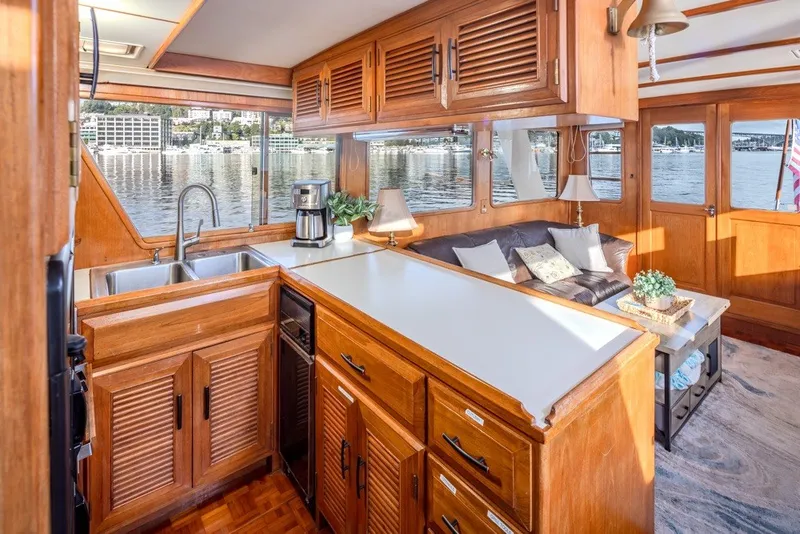 Slide: The Image of Luxurious 1982 Ocean Alexander 50 Mark I yacht interior with wooden cabinetry and waterfront views. - 13
