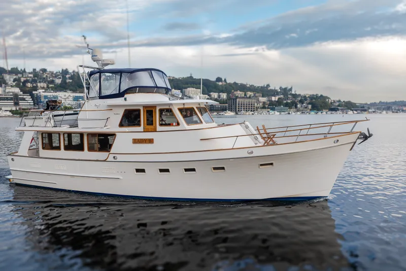 Slide: The Image of 1992 Ocean Alexander 50 Mark I yacht cruising on calm waters under a cloudy sky. - 37