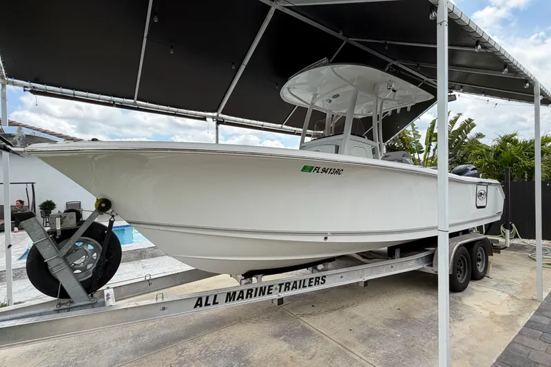 Slide: The Image of 2016 Sea Hunt Gamefish 25 on trailer under canopy, ready for transport. - 1