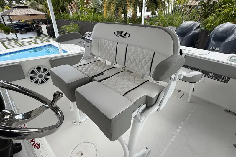 Slide: The Image of 2016 Sea Hunt Gamefish 25 boat interior with cushioned seating and steering wheel. - 13