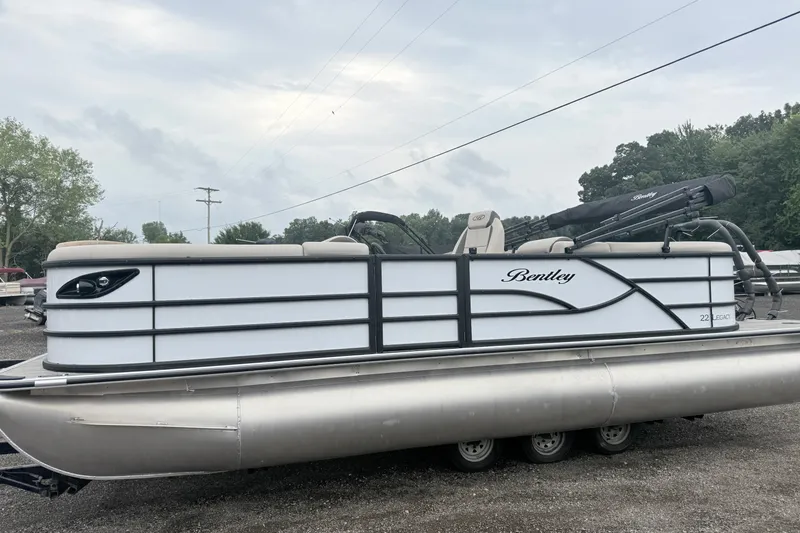 Slide: The Image of 2027 Bentley Pontoons Legacy 223 Navigator, sleek design, parked outdoors, overcast sky. - 1