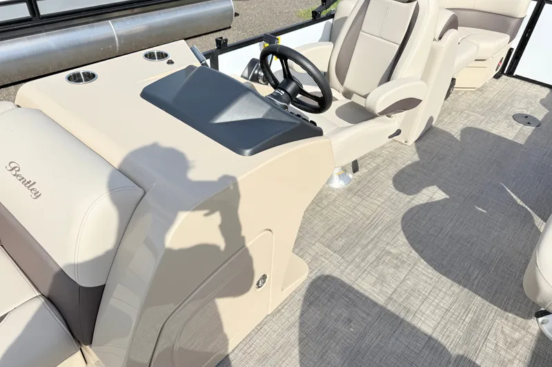 Slide: The Image of 2027 Bentley Pontoons Legacy 223 Navigator interior with beige seating and steering console. - 9