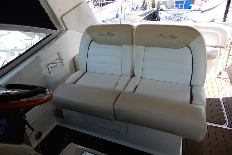 Slide: The Image of 2008 Sea Ray Sundancer 330 cockpit with dual helm seats and wooden steering wheel. - 28