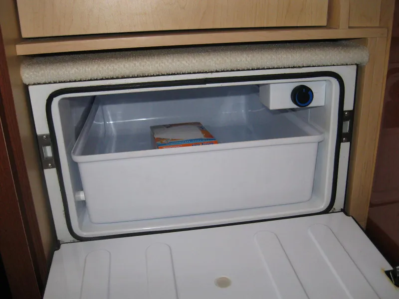 Slide: The Image of Freezer compartment inside a 2008 Sea Ray 330 Sundancer boat, featuring a white interior. - 49