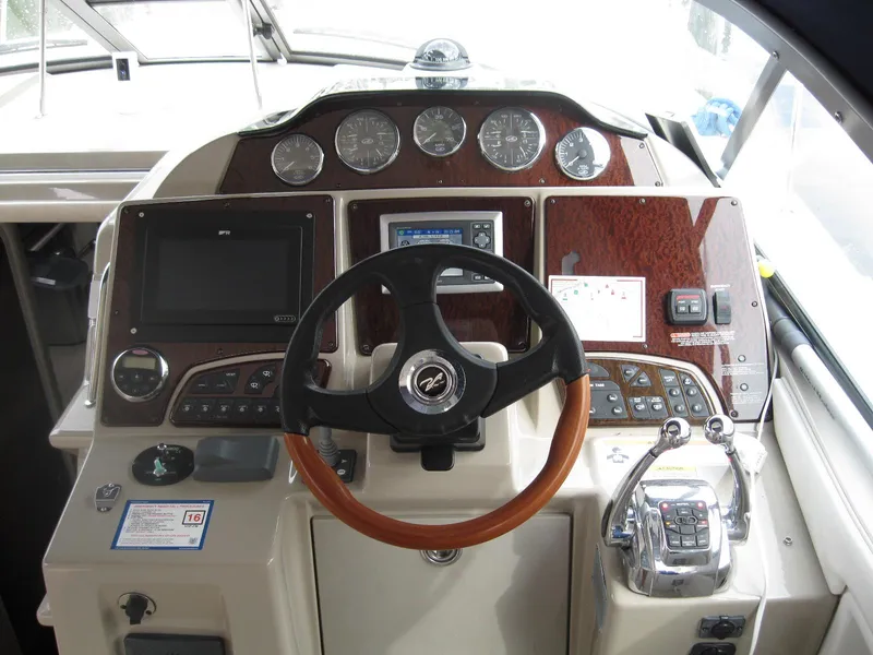 Slide: The Image of 2008 Sea Ray 330 Sundancer helm with gauges, steering wheel, and navigation controls. - 30