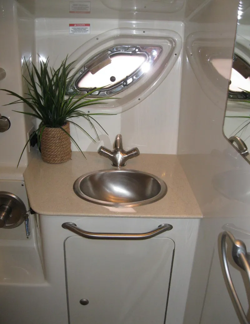 Slide: The Image of 2008 Sea Ray 330 Sundancer bathroom with sink, porthole, and decorative plant. - 54