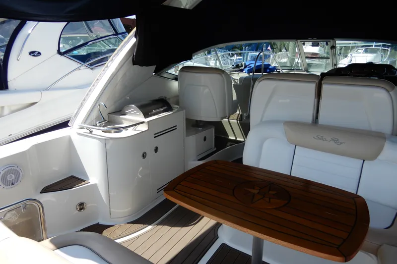 Slide: The Image of 2008 Sea Ray Sundancer 330 interior with seating, table, and kitchenette on a luxury yacht. - 12