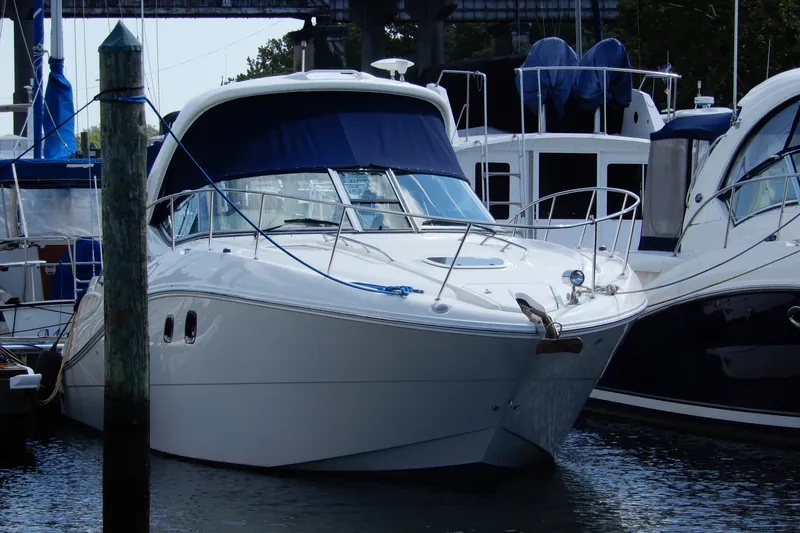 Slide: The Image of 2008 Sea Ray Sundancer 330 yacht docked at marina, featuring sleek design and blue canopy. - 1