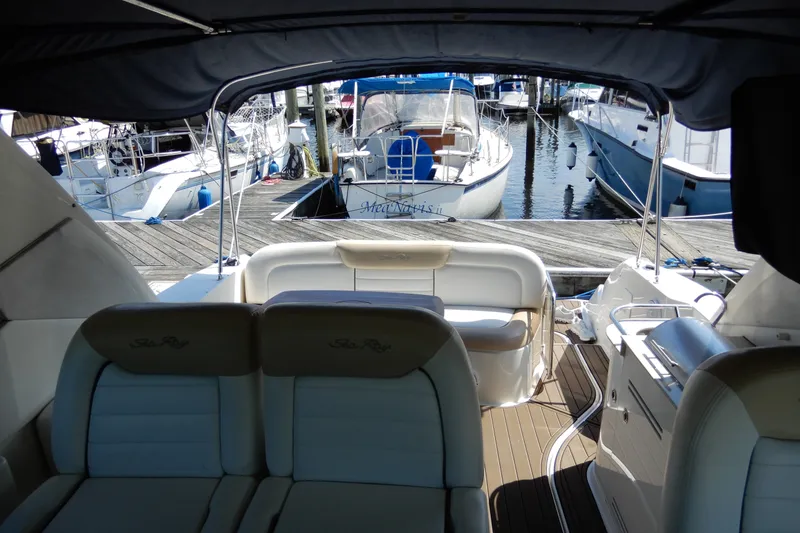 Slide: The Image of 2008 Sea Ray Sundancer 330 interior view at marina, showcasing seating and docked boats. - 9