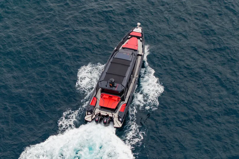 Slide: The Image of Aerial view of a modern boat with red accents cruising through blue water. - 10