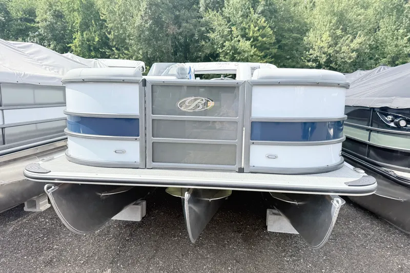 Slide: The Image of 2027 Bentley Pontoons Legacy 223 Navigator, docked, surrounded by trees and covered boats. - 1