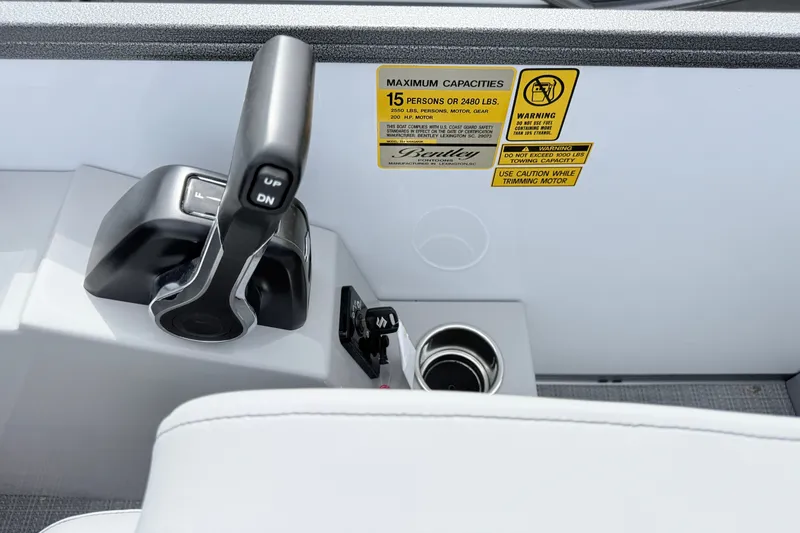 Slide: The Image of Control panel of 2027 Bentley Pontoons Legacy 223 Navigator with capacity warning labels. - 2