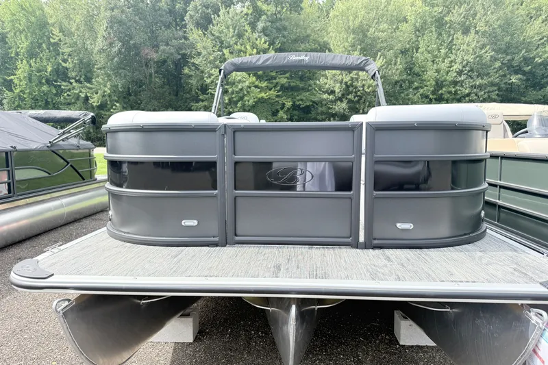 Slide: The Image of 2027 Bentley Pontoons Bolt 223, sleek black design, docked outdoors with lush greenery backdrop. - 2