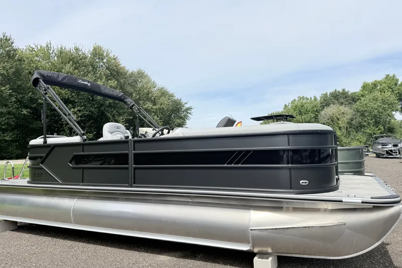 The Image of 2027 Bentley Pontoons Bolt 223 on display, sleek design with lush greenery background. - 1