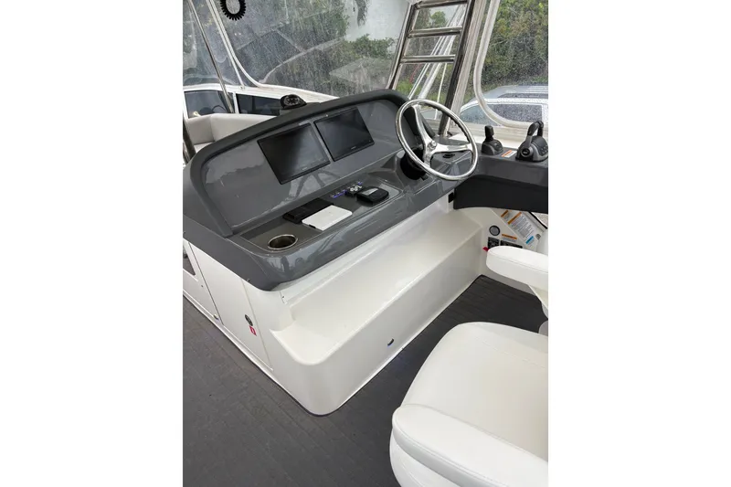 Slide: The Image of Helm of 2025 Riviera 46 Sports Motor Yacht with dual screens and modern controls. - 17