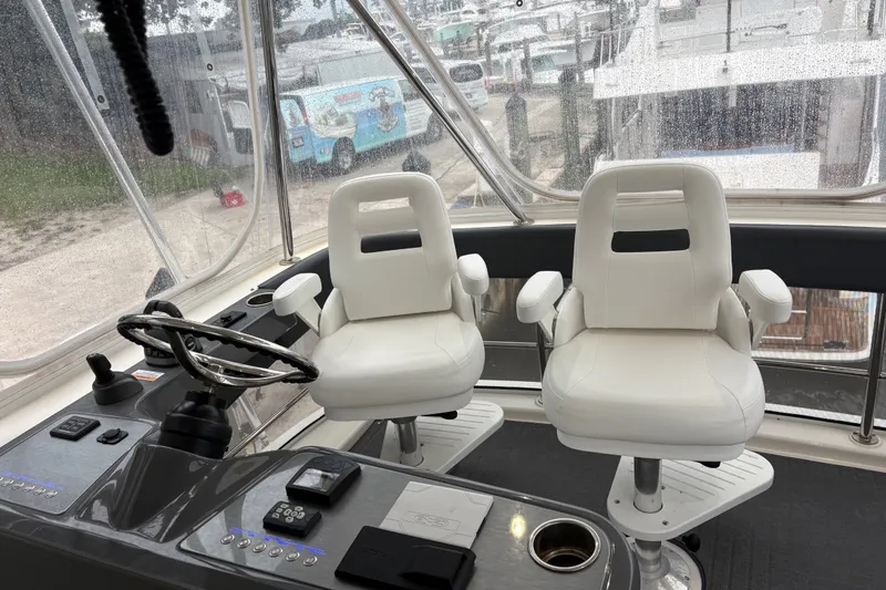 Slide: The Image of Interior helm of 2025 Riviera 46 Sports Motor Yacht with dual white captain chairs. - 23