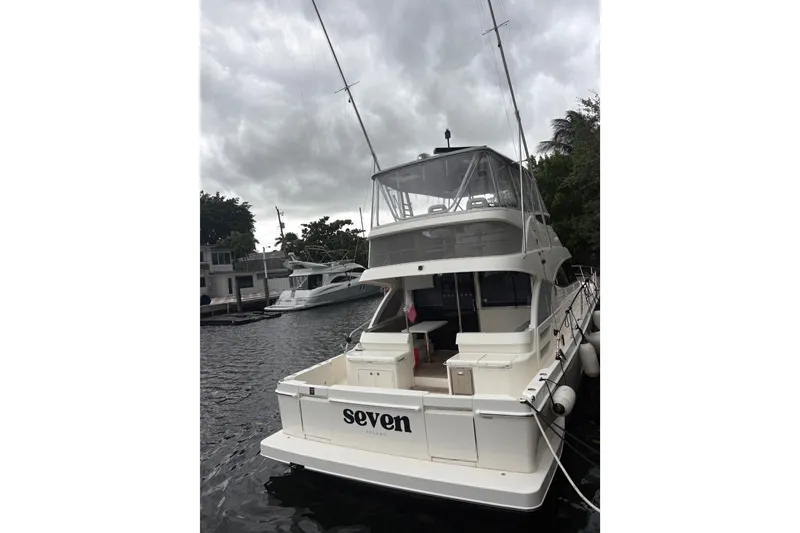 Slide: The Image of 2025 Riviera 46 Sports Motor Yacht docked under cloudy skies. - 5