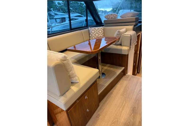 Slide: The Image of Luxurious interior of 2025 Riviera 46 Sports Motor Yacht with elegant seating and wooden table. - 12