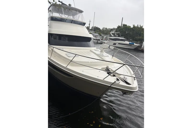Slide: The Image of 2025 Riviera 46 Sports Motor Yacht docked on a calm waterway. - 7