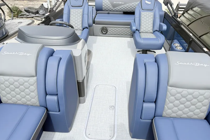 Slide: The Image of Luxurious interior of 2026 South Bay 525UL DC pontoon boat with blue and gray seating. - 8