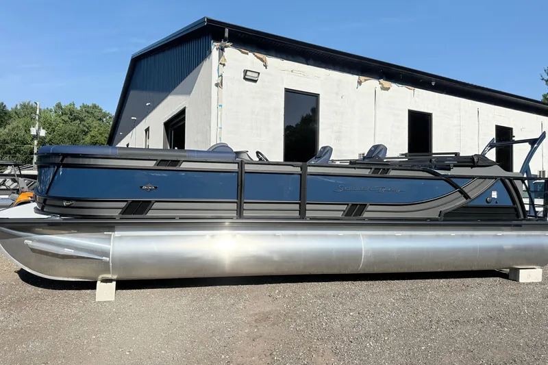 The Image of 2026 South Bay 525UL DC pontoon boat parked outside a building on a sunny day. - 1