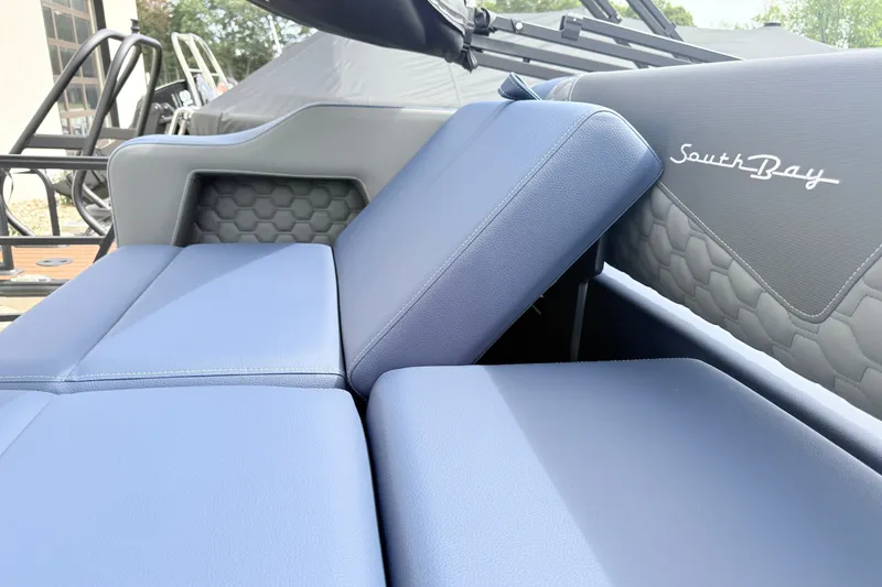 Slide: The Image of 2026 South Bay 525UL DC boat interior with blue cushioned seating and hexagonal pattern. - 19
