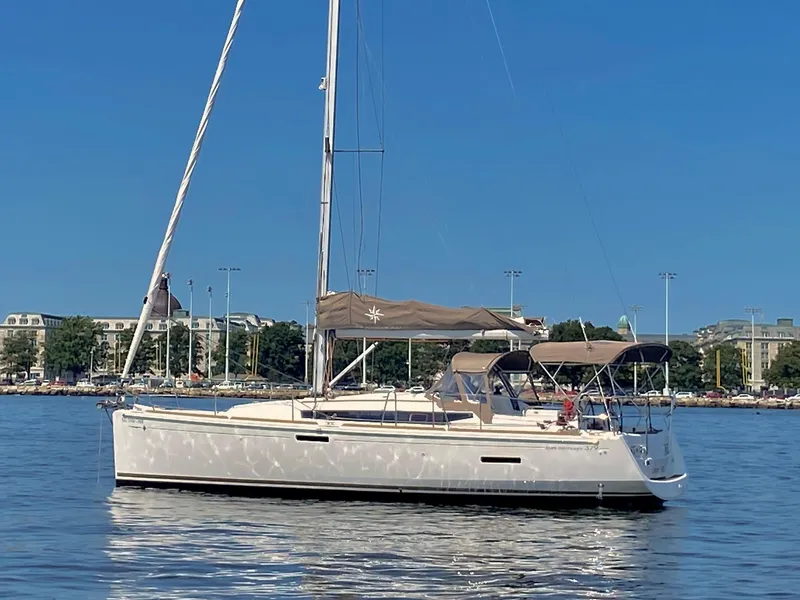 Slide: The Image of 2015 Jeanneau Sun Odyssey 379 sailboat on calm water, clear blue sky background. - 6