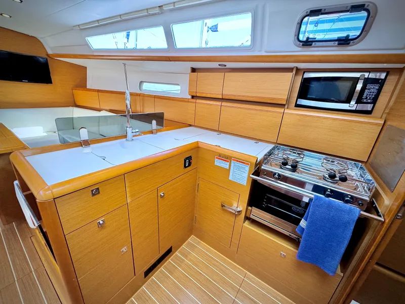 Slide: The Image of Modern kitchen interior of 2015 Jeanneau Sun Odyssey 379 sailboat with wood cabinetry. - 46