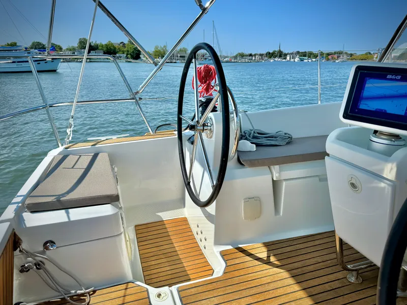 Slide: The Image of 2015 Jeanneau Sun Odyssey 379 cockpit with steering wheel, wooden deck, and navigation equipment. - 25
