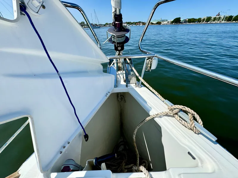 Slide: The Image of 2015 Jeanneau Sun Odyssey 379 sailboat anchor locker with ropes, docked on calm water. - 16