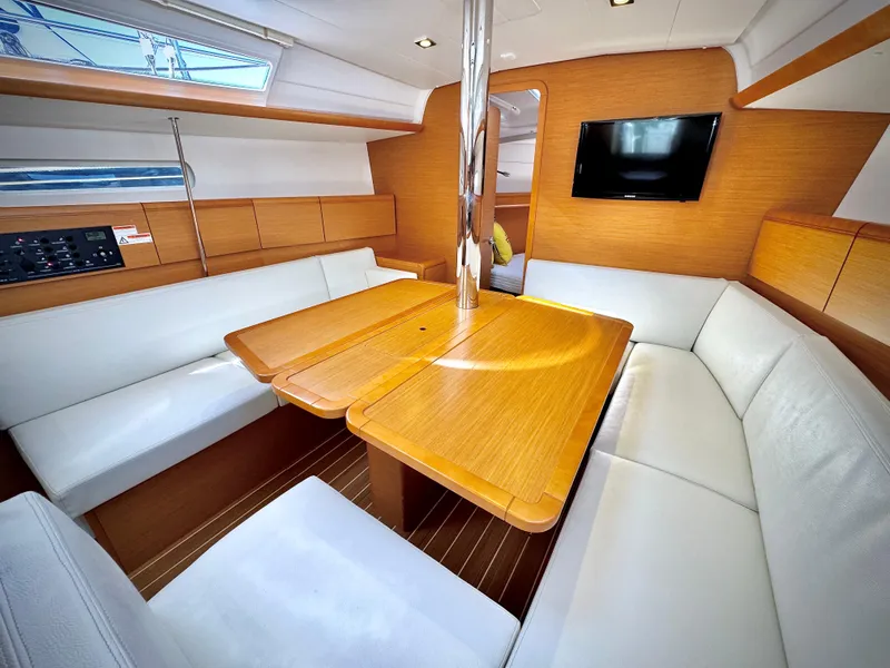 Slide: The Image of Interior of 2015 Jeanneau Sun Odyssey 379 yacht with wooden table and white seating. - 35