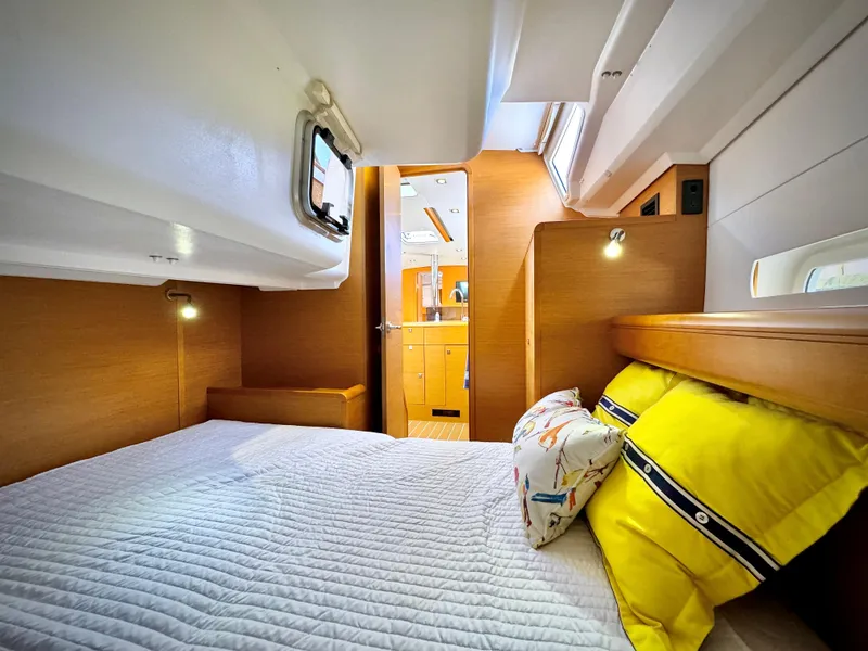 Slide: The Image of Cozy cabin interior of 2015 Jeanneau Sun Odyssey 379 sailboat with bright bedding. - 49