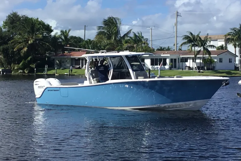 Slide: The Image of 2025 Sportsman Open 322 Center Console boat on a sunny waterfront. - 7