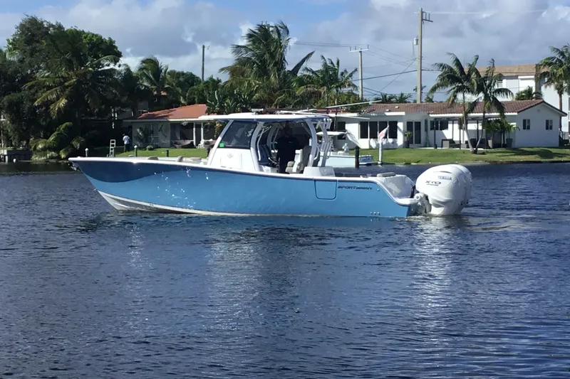Slide: The Image of 2025 Sportsman Open 322 Center Console boat on a calm waterway, surrounded by palm trees. - 9