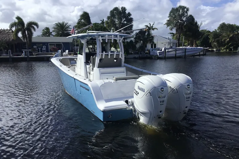 Slide: The Image of 2025 Sportsman Open 322 Center Console boat with twin Yamaha engines on a calm waterway. - 1
