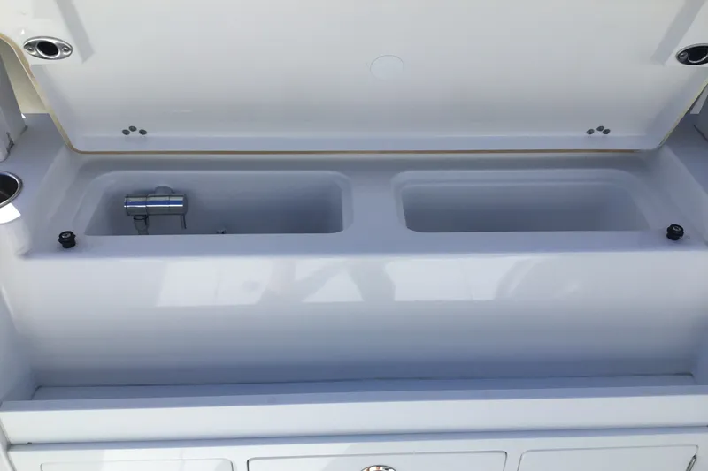 Slide: The Image of 2025 Sportsman Open 322 Center Console livewell with open lid, showcasing dual compartments. - 60