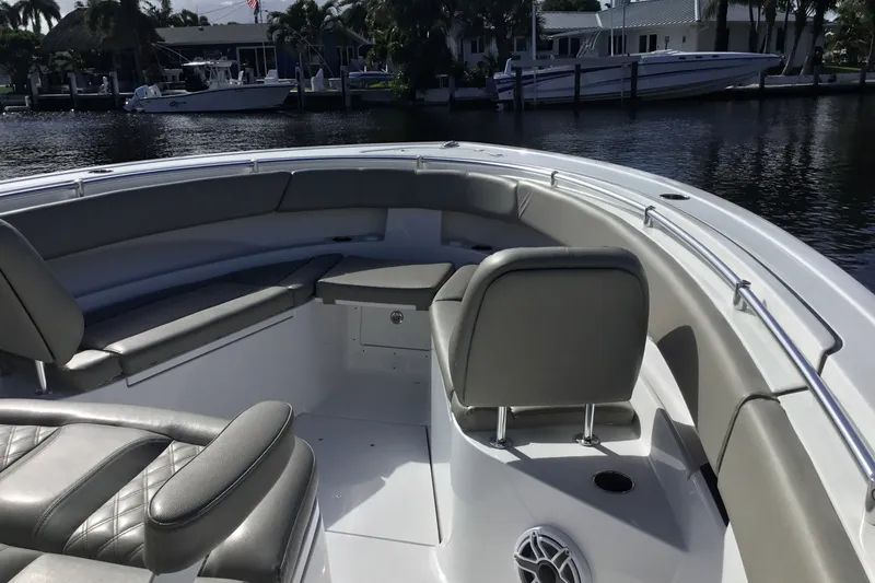 Slide: The Image of 2025 Sportsman Open 322 Center Console boat interior with cushioned seating and waterfront view. - 20