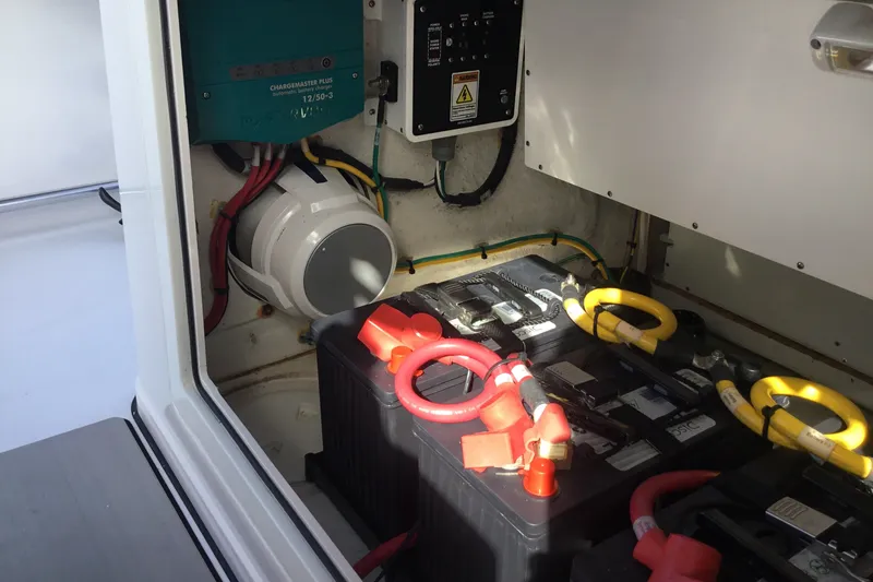 Slide: The Image of 2025 Sportsman Open 322 Center Console battery compartment with wiring and charger. - 47