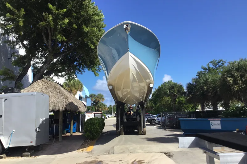 Slide: The Image of 2025 Sportsman Open 322 Center Console boat on trailer, sunny day, palm trees nearby. - 74