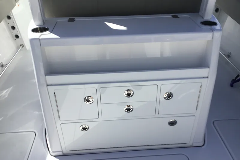 Slide: The Image of 2025 Sportsman Open 322 Center Console storage area with drawers and cup holders. - 58