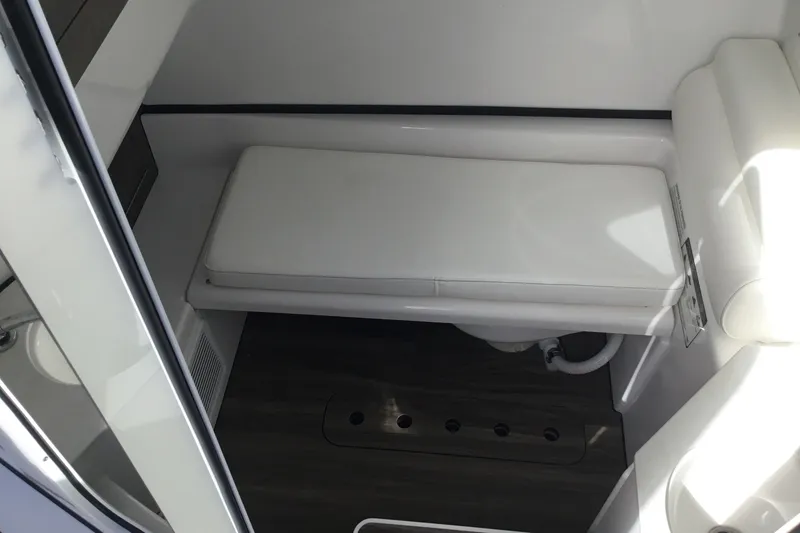 Slide: The Image of 2025 Sportsman Open 322 Center Console interior with cushioned seating and wood flooring. - 32
