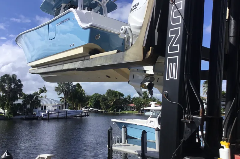 Slide: The Image of 2025 Sportsman Open 322 Center Console boat lifted by crane near waterfront. - 76