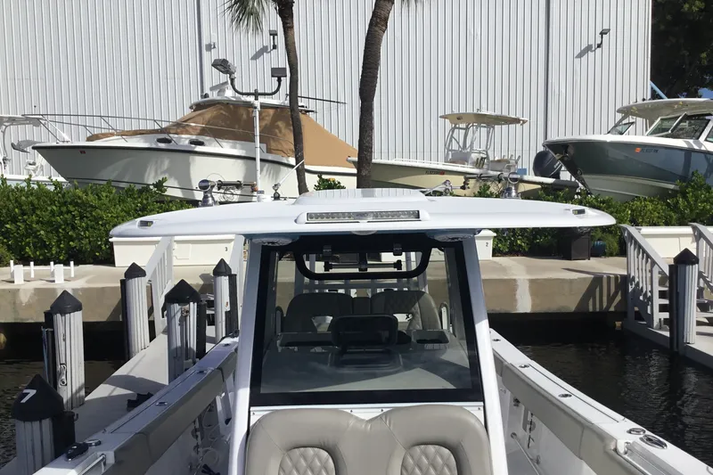 Slide: The Image of 2025 Sportsman Open 322 Center Console boat docked at marina with other boats. - 15
