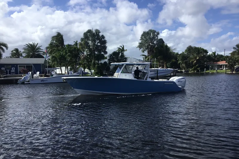 Slide: The Image of 2025 Sportsman Open 322 Center Console boat on a scenic waterway. - 2