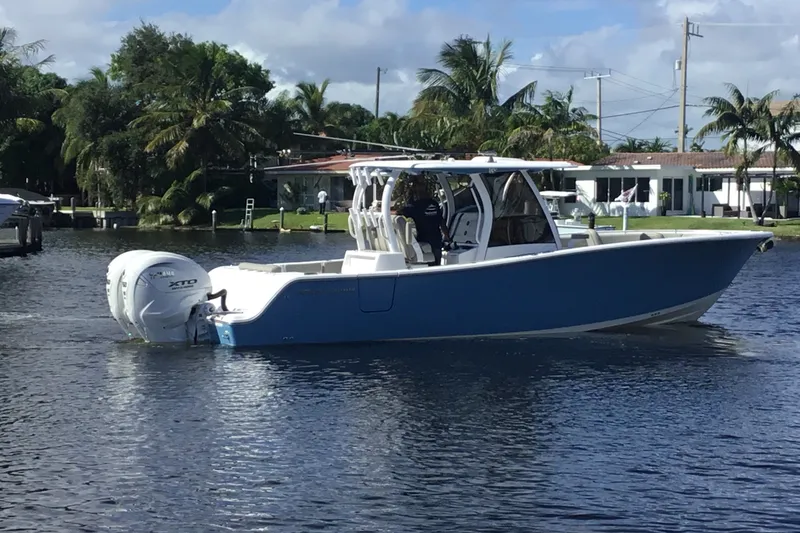 Slide: The Image of 2025 Sportsman Open 322 Center Console boat on water, surrounded by palm trees. - 8