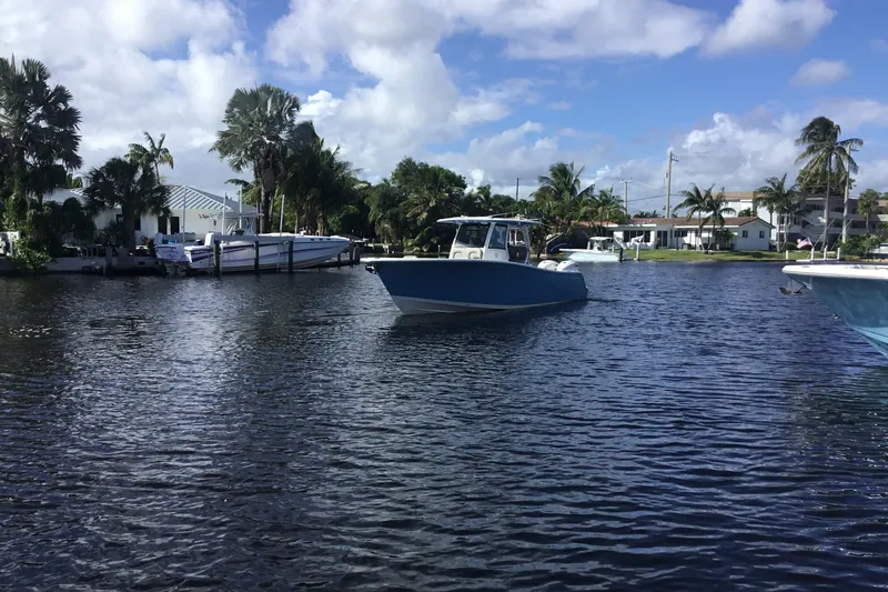 Slide: The Image of 2025 Sportsman Open 322 Center Console boat on a sunny waterfront with palm trees. - 3
