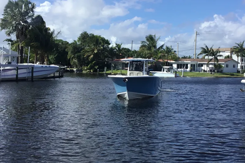 Slide: The Image of 2025 Sportsman Open 322 Center Console boat cruising on a sunny day in a tropical setting. - 4