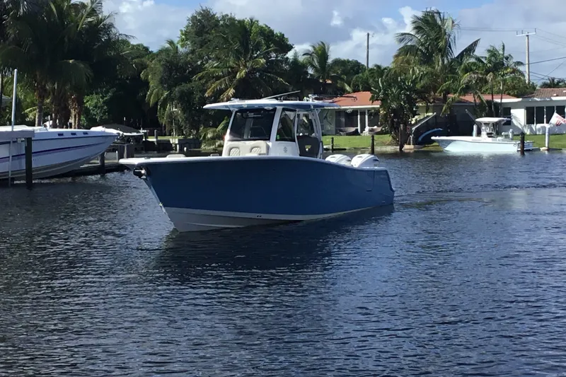 Slide: The Image of 2025 Sportsman Open 322 Center Console boat cruising on a calm waterway. - 11