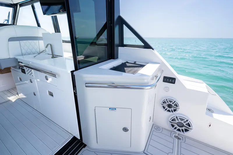 Slide: The Image of Luxurious 2022 Regal 36 Grande Coupe yacht interior with sleek kitchen and ocean view. - 24